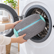 Cushioned shoe wash bag being placed into a washing machine